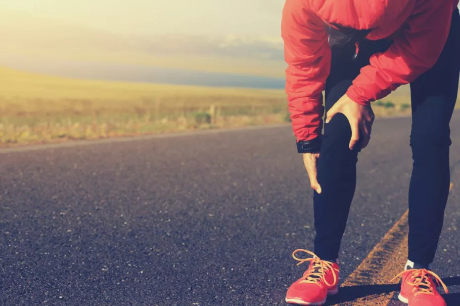 Homme qui se tient le genou sur route, habit running